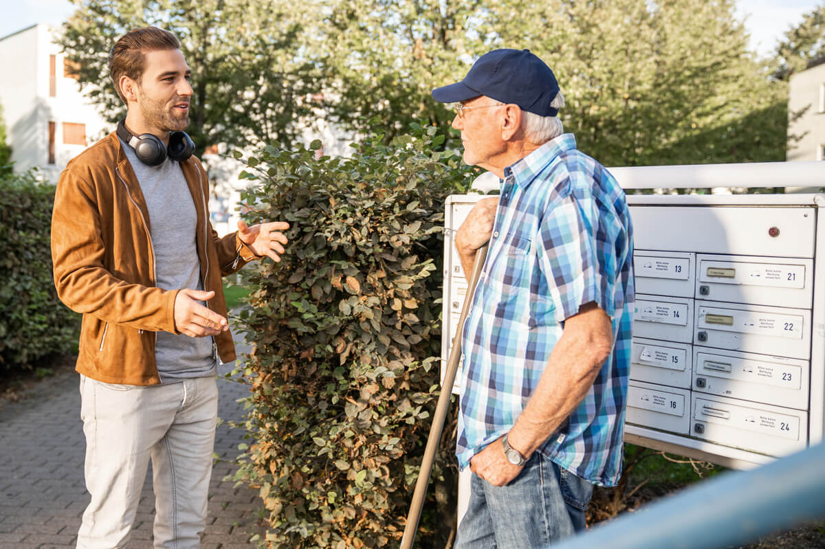 Gute Nachbarn: Ein junger und ein älterer Herr unterhalten sich angeregt