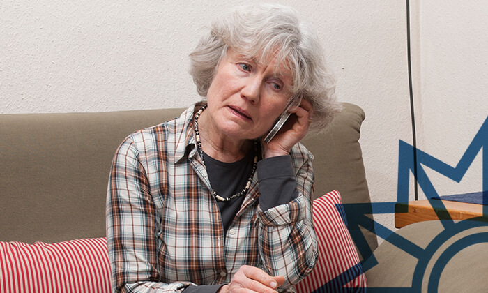 Ältere Frau hält einen Telefonhörer an das Ohr